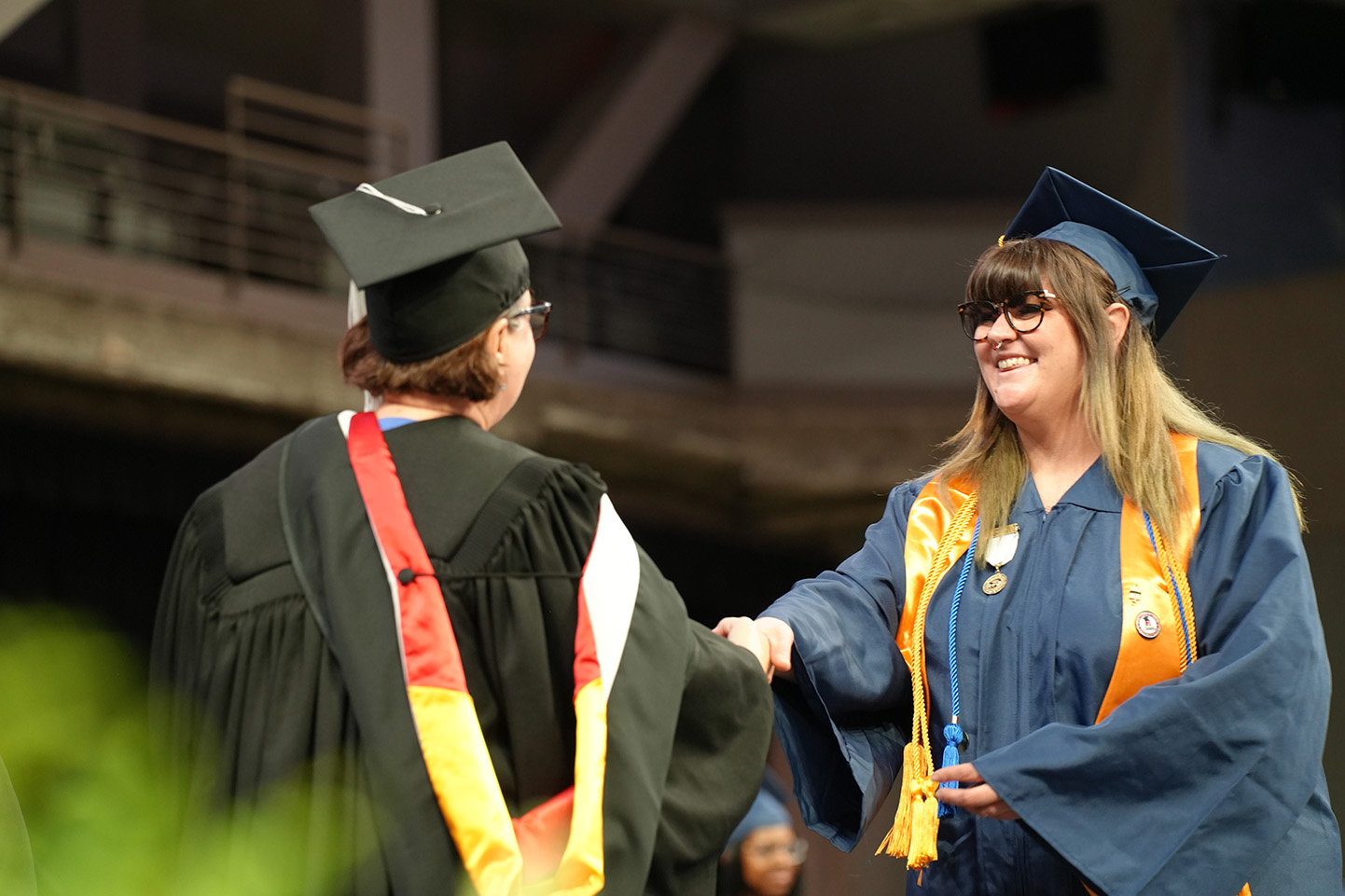SCC Graduate, Joeanna Moore, shaking hands with college president on graduation stage.
